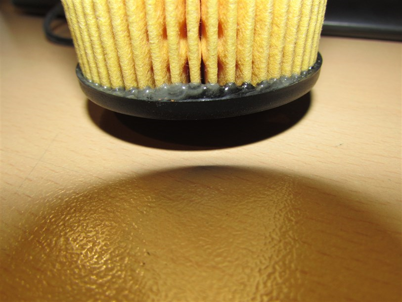 Вклейка фильтрующего элемента в корпус низкого качества: неровное распределение клея, видны подтёки клея.